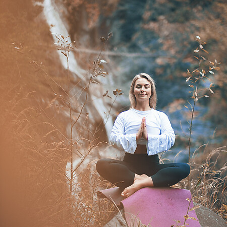 Yoga in der Natur mit Wasserfall im Hintergrund