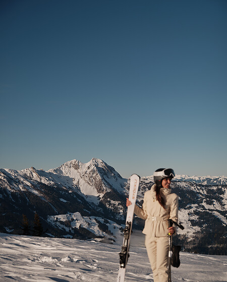 Frau mit Ski am Gipfel