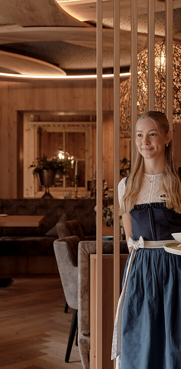 Service Kraft serviert im Dirndl Abendessen im Hotelrestaurant 