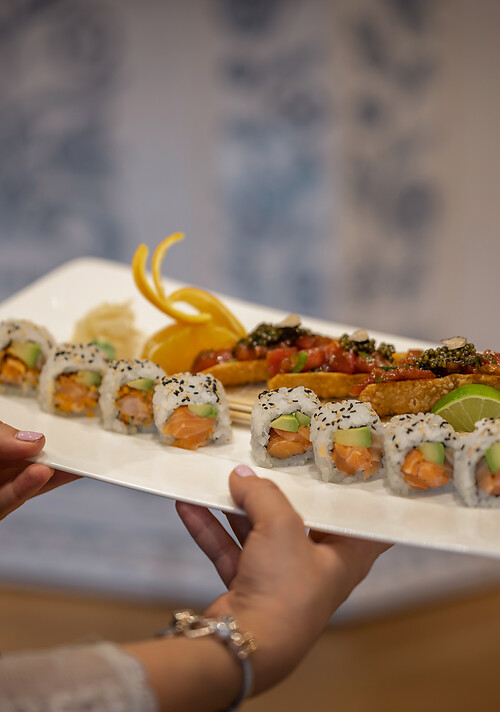 Sushi Roll & Philadelphia Roll auf weißem Teller vor altem Ofen