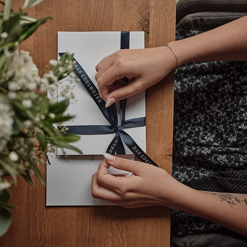 Frau im Dirndl verpackt einen Hotel Gutschein als Geschenk für Geburtstag, Weihnachten, Ostern, Jubiläum