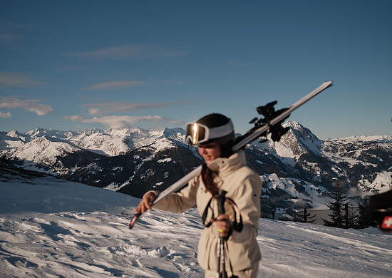 Paar beim Skifahren dank Ski In Ski Out Resort in Österreich bei Sonnenschein