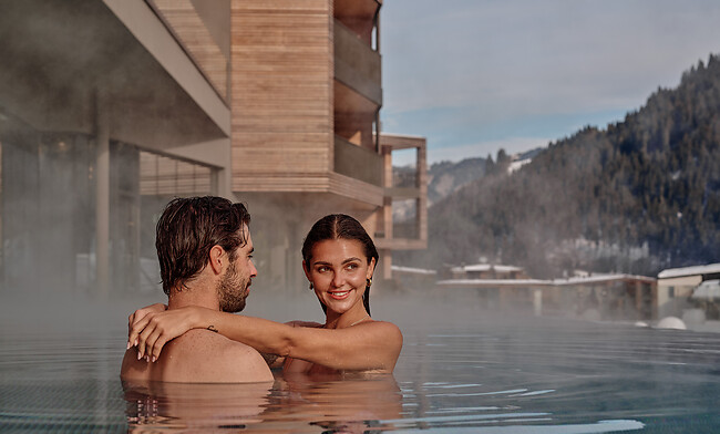 paar im pool vor 5 sterne hotel in den bergen