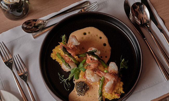Garnelen Risotto mit Kavier und Spargel auf schwarzem Teller im Restaurant Großarl