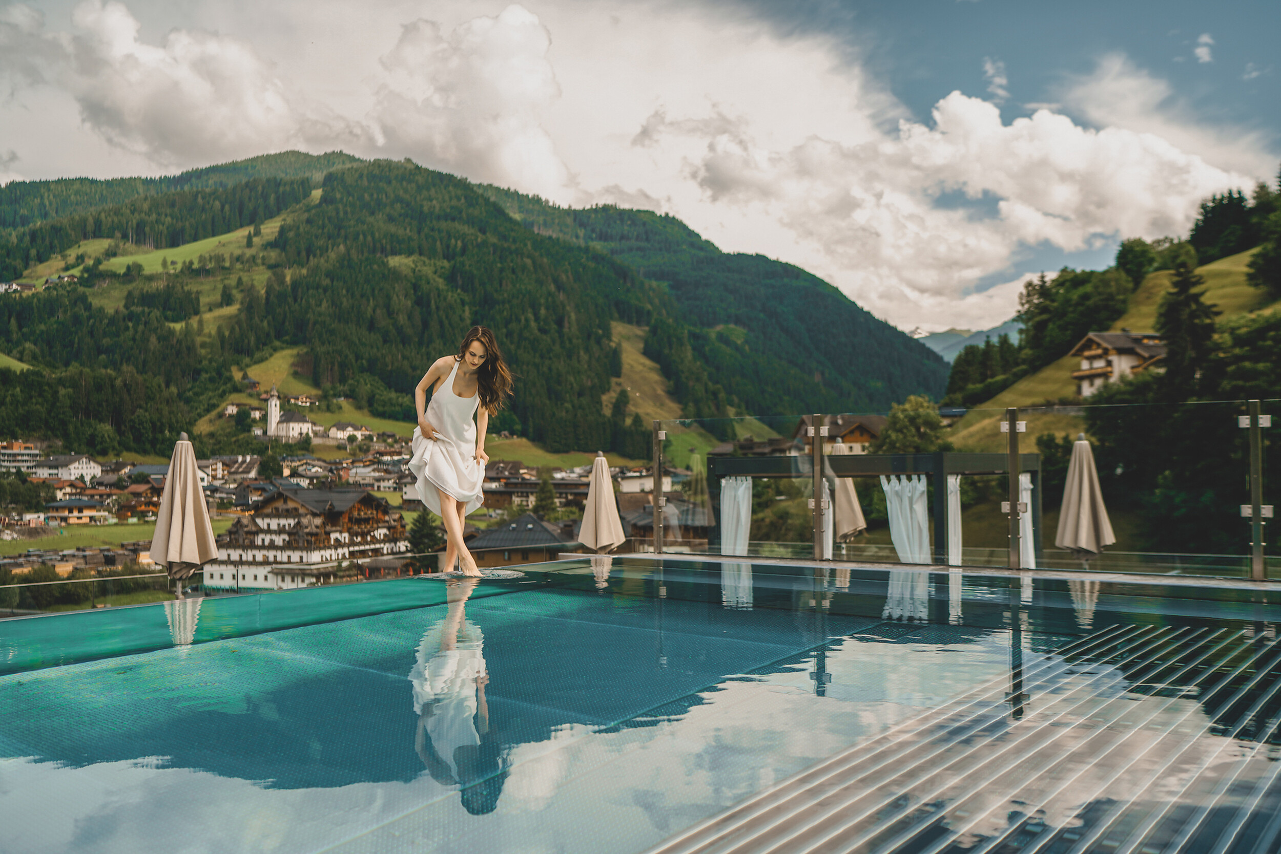 Frau im Infinity Pool im salzburger Land mit Blick auf die Bergwelt von Großarl