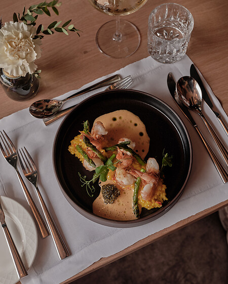 Black plate with shrimp risotto in a restaurant grossarl