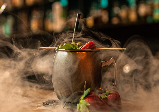 Cocktail with strawberries and nitrogen vapour at a bar Salzburg