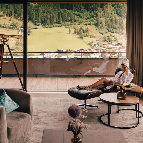 Frau liegt im Sessel und genießt die Aussicht aus dem Luxushotel in Österreich